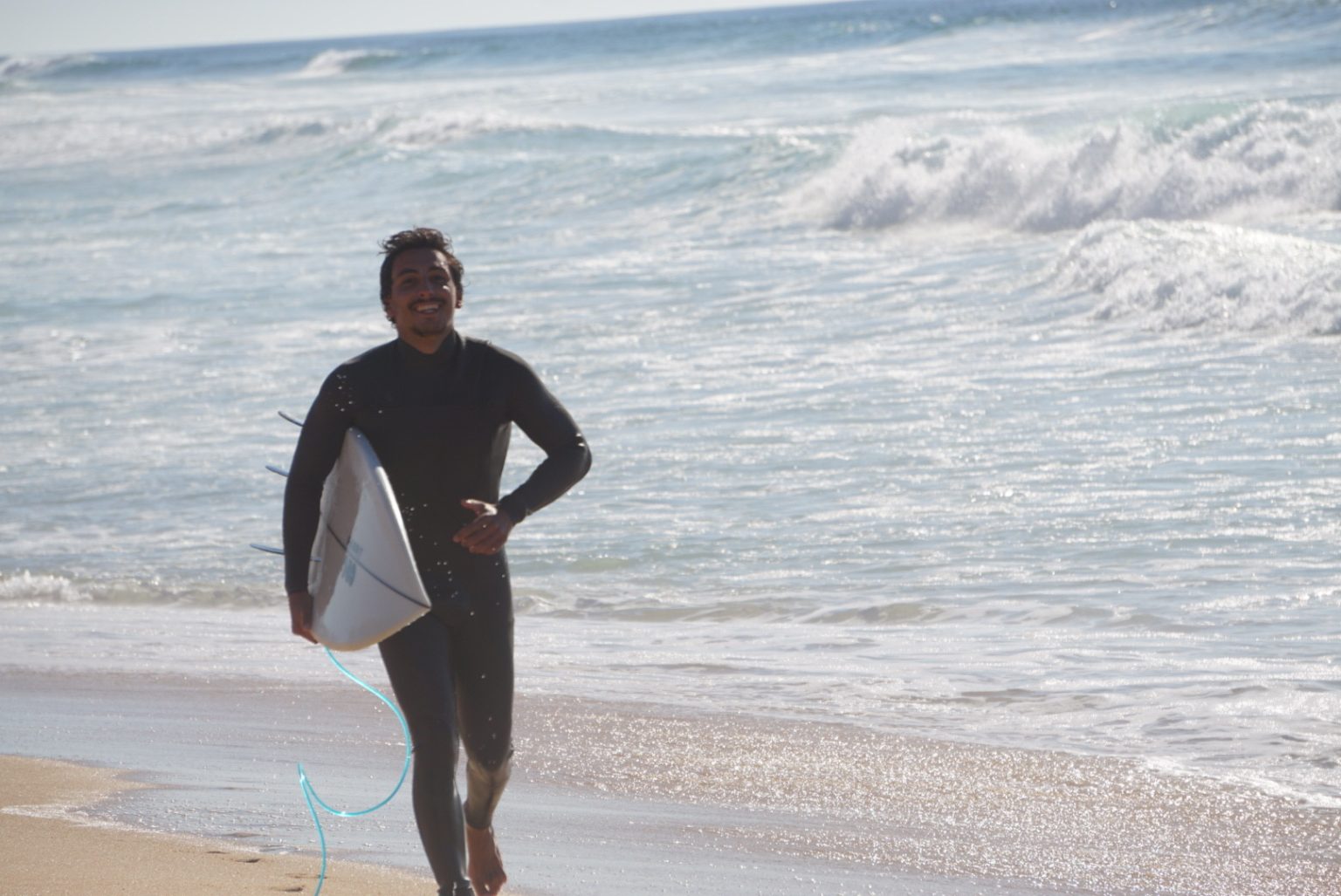 Surfer leaving the sea with a board