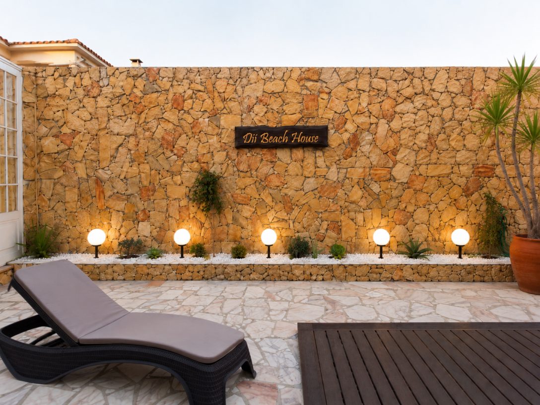 Muro de pedra com o nome Dii e iluminação exterior
